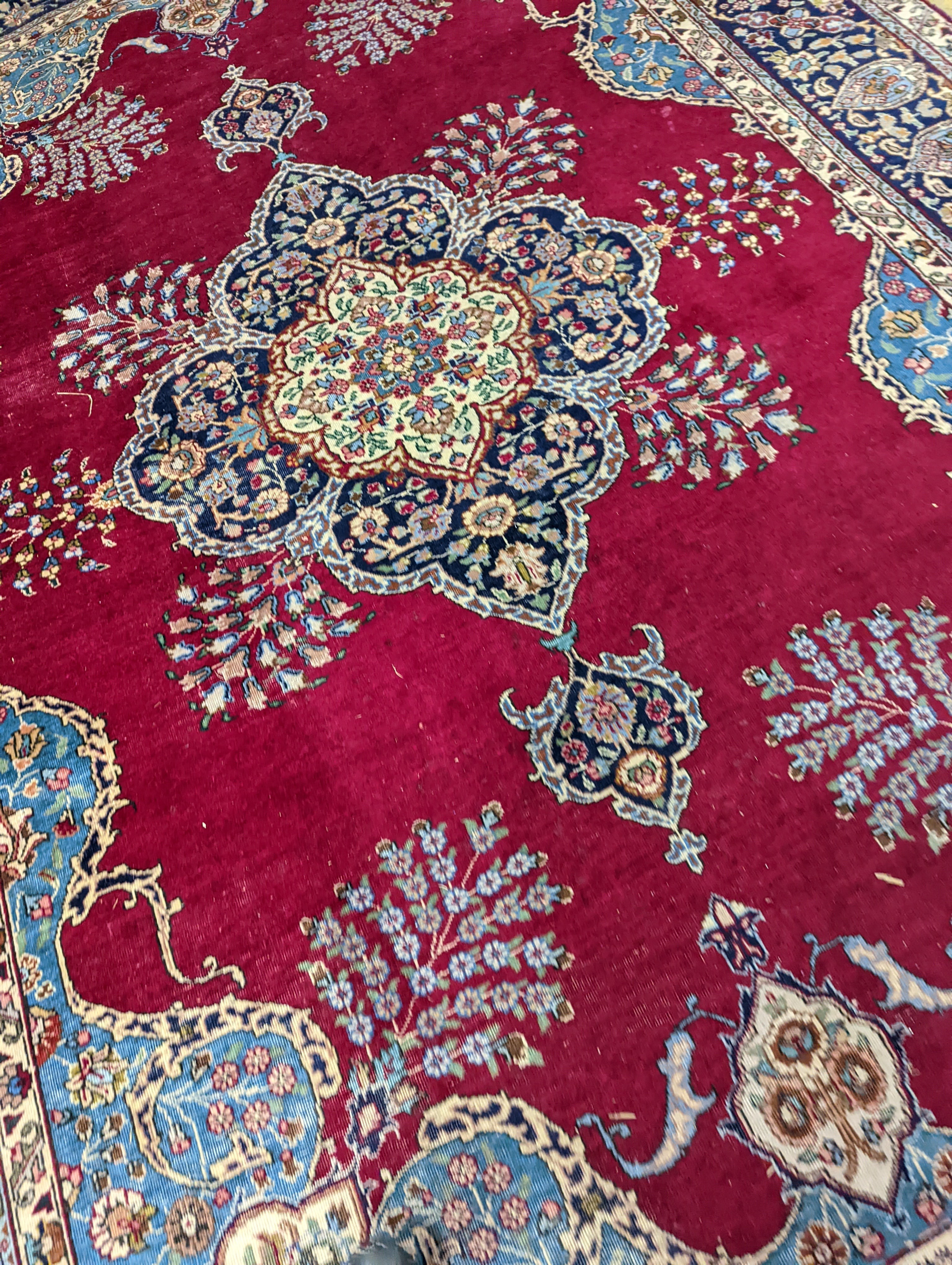 A Tabriz burgundy ground carpet, 350 x 240cm